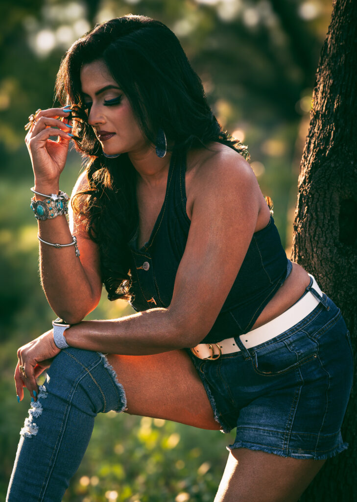 Natural light portrait of Arpita leaning against a tree in denim clothing during an outdoor photography session at Brushy Creek Park near Austin, Texas.