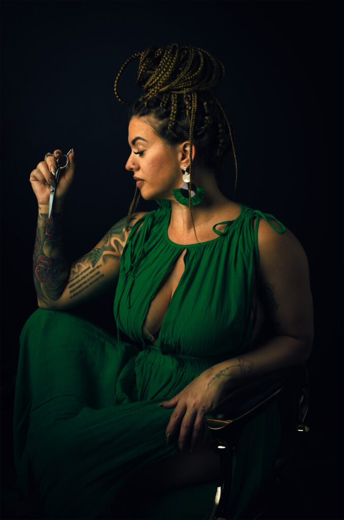 Fine art portrait of Cuban hairstylist in a green dress, holding scissors, photographed by Austin fine art portrait photographer Javier Shirley.